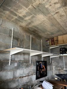 Pose d’étagères murales dans un garage lors de travaux de bricolage à Dijon